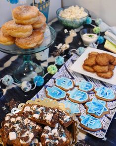 a table topped with lots of desserts and cookies