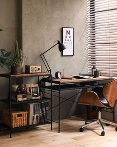 a desk with a lamp, bookshelf and pictures on the wall behind it