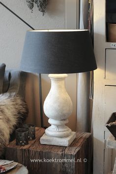 a white lamp sitting on top of a wooden table