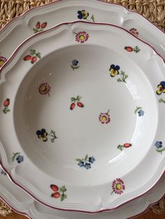 a white plate with red trim and flowers on it