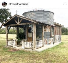 an old wooden house with a metal water tank in the back yard and porch area