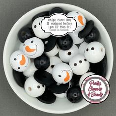 a bowl filled with lots of black and white plastic balls next to a sticker