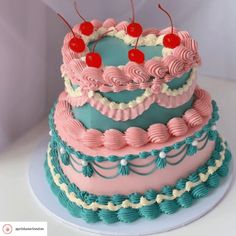 there is a three layer cake with cherries on the top, and blue icing