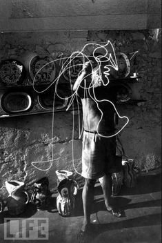 an old black and white photo of a person with wires in front of a wall