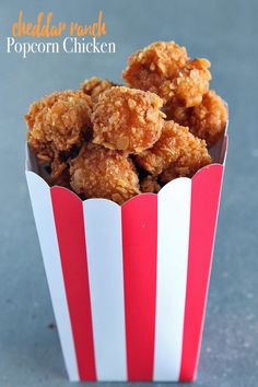 fried popcorn chicken in a red and white striped paper cup with text overlay that reads,