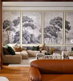 a living room filled with furniture and paintings on the wall