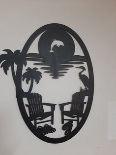 a metal wall art with two chairs and palm trees