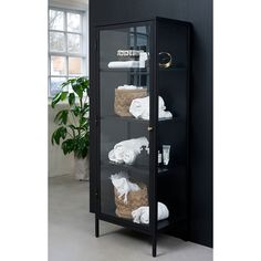 a black cabinet with towels and other items in it