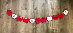 an apple and button garland on a wooden floor