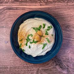 a blue bowl filled with food on top of a wooden table