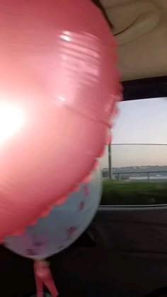 a pink balloon sitting in the passenger seat of a car