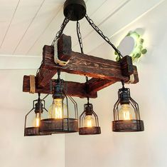 three light fixtures hanging from a wooden beam