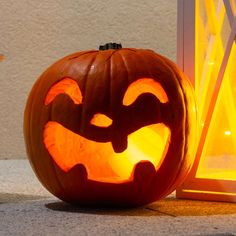 a carved pumpkin sitting next to a window