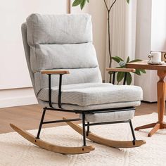 a rocking chair in a living room next to a table