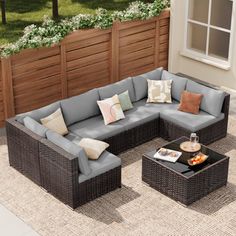 an outdoor living room with grey wicker furniture