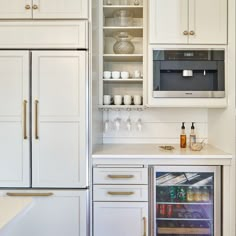 a kitchen with white cabinets and an open refrigerator