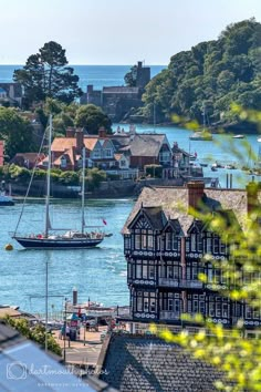 a sailboat is in the water near some houses