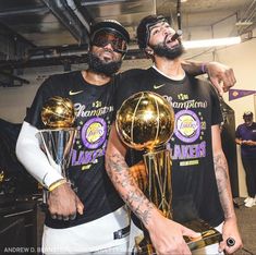 two basketball players holding trophies in their hands