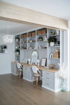 a room that has some shelves and chairs in it, with white furniture on the walls