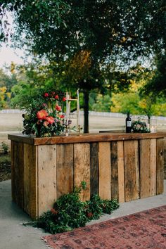 an outdoor bar with flowers and candles on it