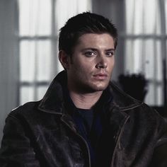 a man in a leather jacket looking at the camera