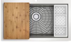 a wooden cutting board sitting on top of a white microwave oven with the door open