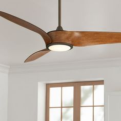 a ceiling fan that is hanging from the ceiling in front of a window with two windows