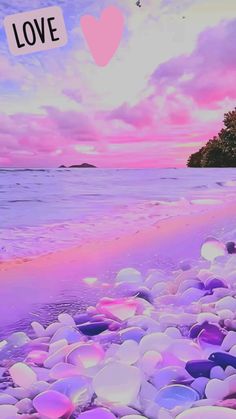 the beach is covered in rocks and has a pink sky with white clouds above it