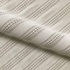 a close up shot of the fabric in beige and white stripes on a plain background