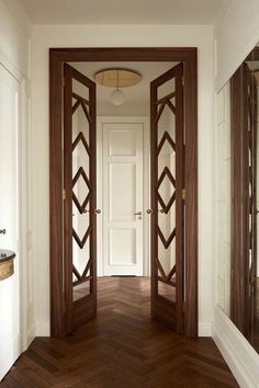 an empty hallway with wooden doors and mirrors