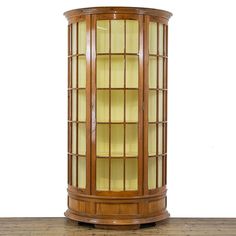 a wooden corner cabinet with glass doors on top and bottom, sitting on a hard wood floor