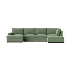 a green sectional couch sitting on top of a white floor