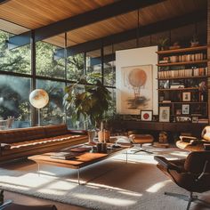 a living room filled with lots of furniture and large windows overlooking the trees in the distance