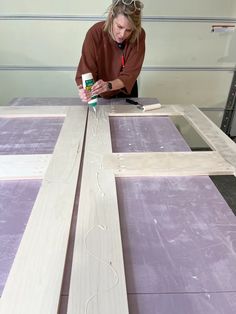 a woman is working on some wood planks