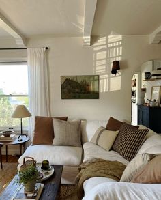 a living room filled with lots of furniture and pillows on top of a wooden table