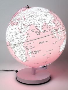 a pink and white illuminated globe on a stand with plugged in wires attached to it