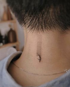 a person with a small bird tattoo on their neck