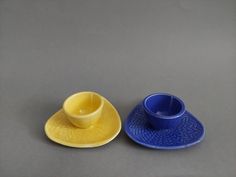 two cups and saucers sitting next to each other on a gray tableclothed surface