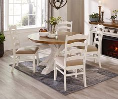 a dining room table with four chairs and a fire place in the fireplace behind it