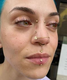 a woman with blue hair and piercings on her nose