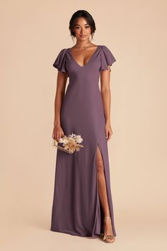 a woman in a long purple dress with a slit down the side and a flower bouquet