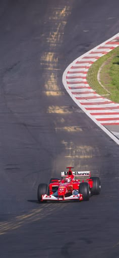 a man driving a red race car around a track