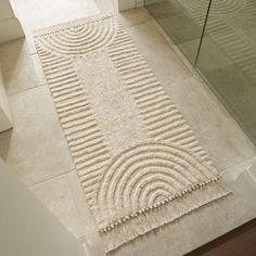 a bath room with a toilet and a rug on the floor in front of it