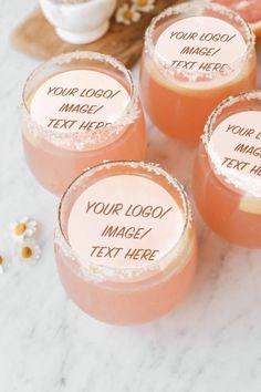 four glasses filled with drinks sitting on top of a table