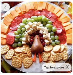 a turkey shaped platter with crackers, grapes, and cheeses on it