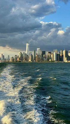 the city skyline as seen from a boat on the water with waves in foreground