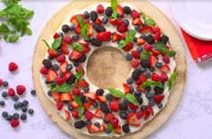 a cake decorated with berries and mint leaves