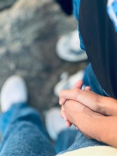 a person holding their hands together while sitting down