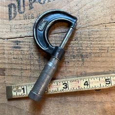 a pair of scissors sitting on top of a wooden table next to a measuring tape