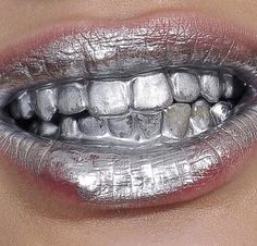 a woman's mouth with silver and white makeup